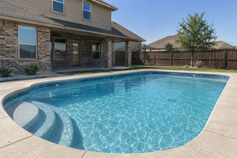 Light blue quartz finish in a backyard pool with bright aqua water