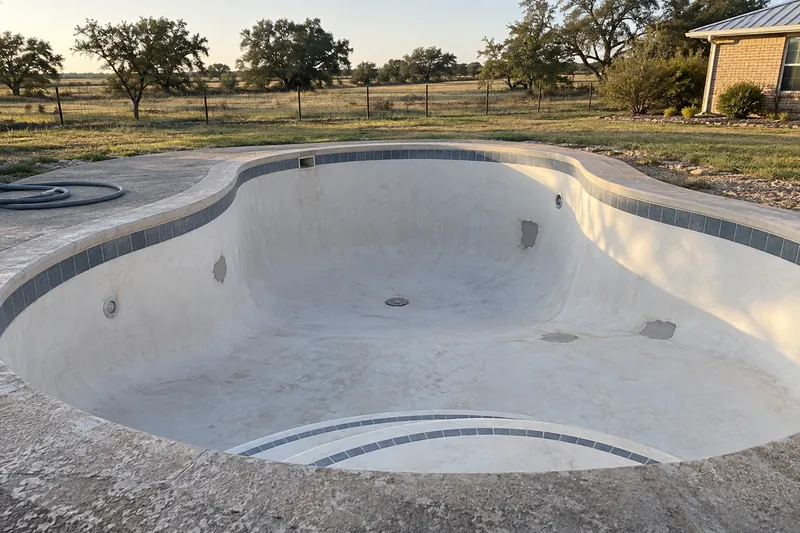Gray patches on an old plaster pool shell ready for resurfacing