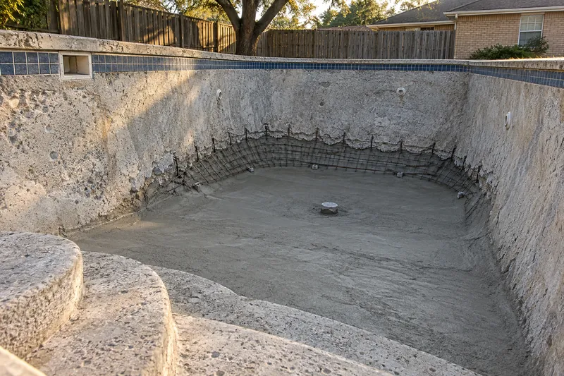 New shotcrete raising the floor of an old diving pool's deep end