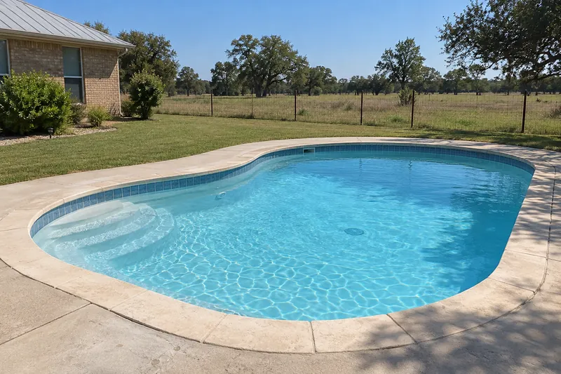 White pool finish in a rural backyard pool beside open pasture